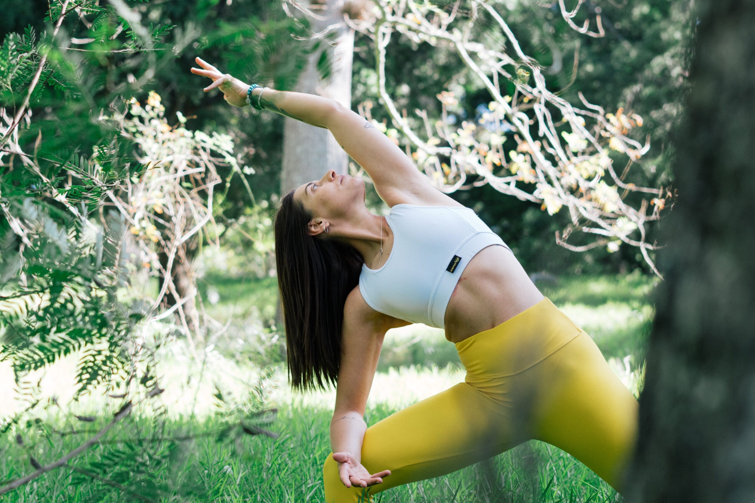 woman doing yoga pose next to trees