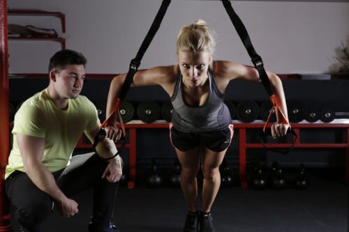 woman doing weight training with personal trainer