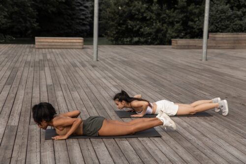 two women doing power yoga outside
